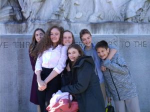A group of eighth graders pose in front of a statue in Seattle